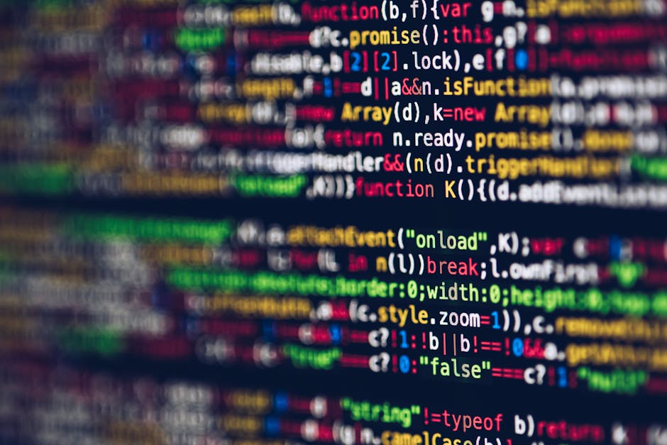 A close-up photograph of a computer screen displaying lines of colorful programming code. The code includes syntax highlighting with words in red, green, blue, yellow, and white, set against a black b